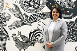 Woman standing in front of a mural