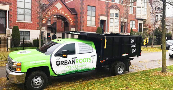 Urban Roots lawn service truck in front of a brick building