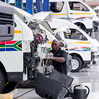 Man working on a taxi van inside an auto garage