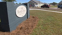 North Park Estates sign on gray brick wall