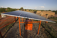 Close up view of a large solar panel next to a stone building in Tanzania
