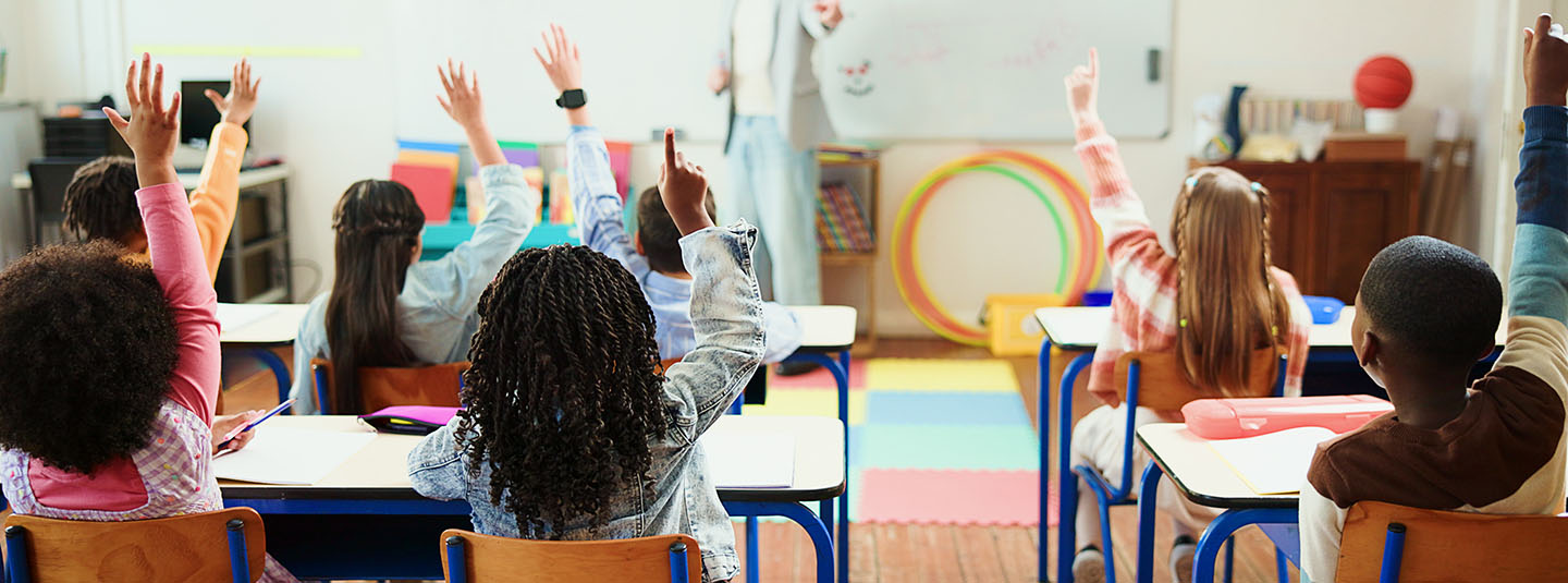 Kids in classroom raising their hands