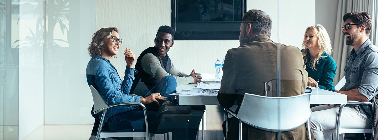 Five people in a conference room talking