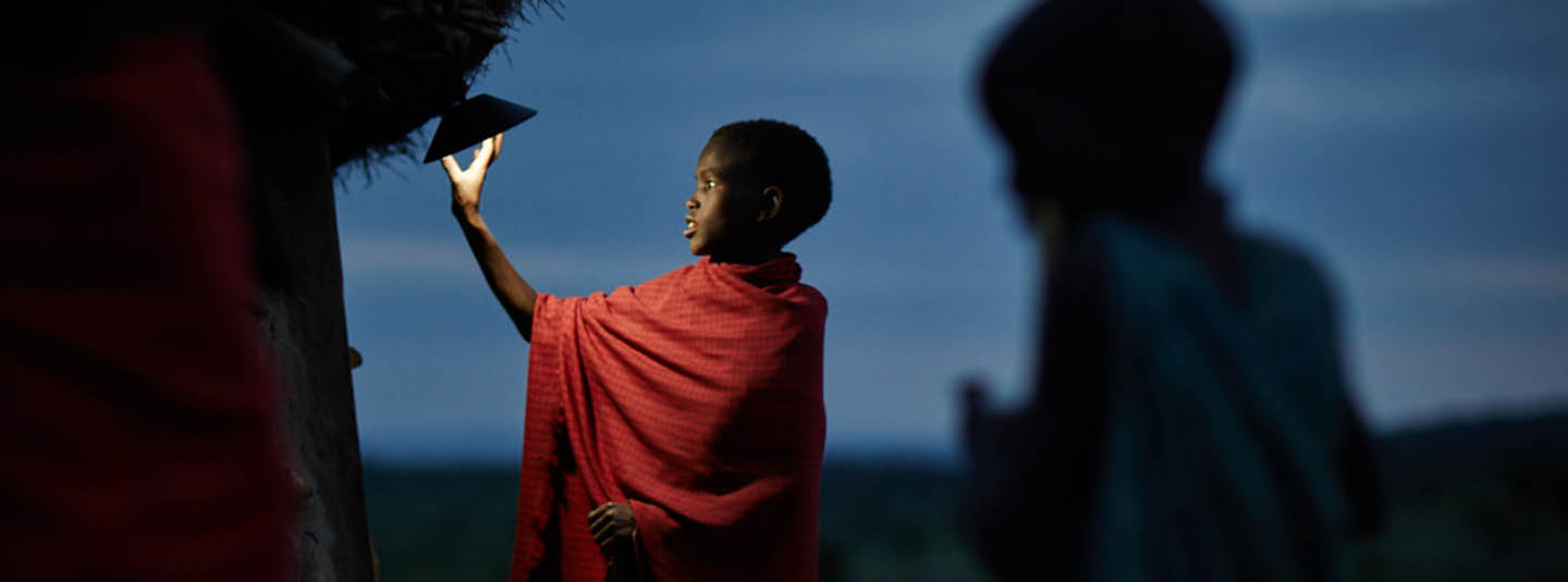 Child in rural African village turning on a light