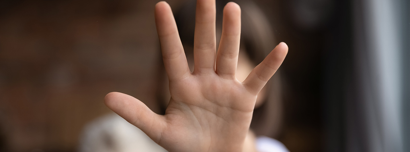 Blurred image of child with hand outstretched covering their face
